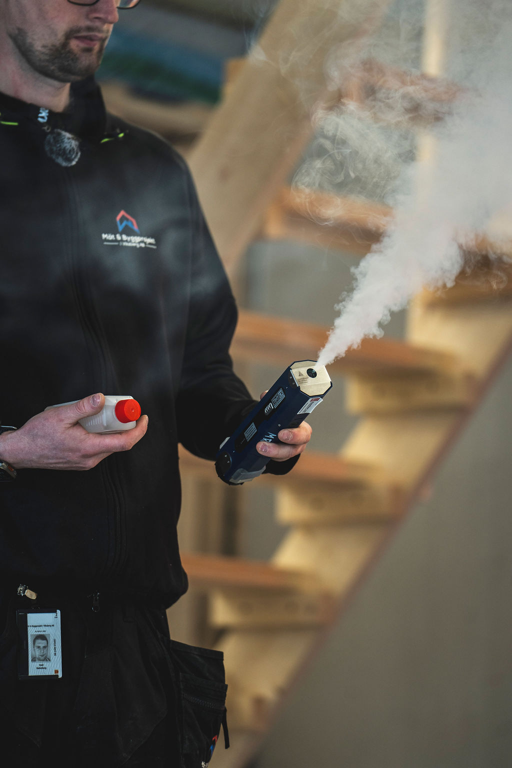 Byggnadsingenjör kontrollerar rökflöde under tätighetsprovning i Västerås